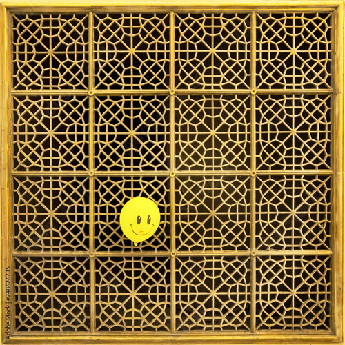 Photography Old metal gold aeration grid with yellow smiling balloon in a foreground