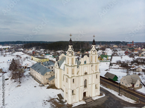 Old catholic church in Belarusian village. White church. All in the snow. View from above. View from the sky. The photo was taken by drone, copter.