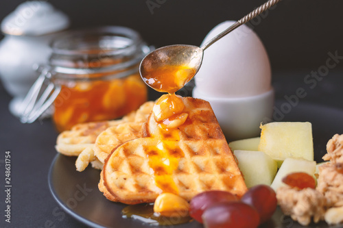 toned non-contrast image. matte effect. comprehensive breakfast to keep slim figure. natural sugar substitutes. slices of fresh fruit for breakfast. served on a dark plate photo