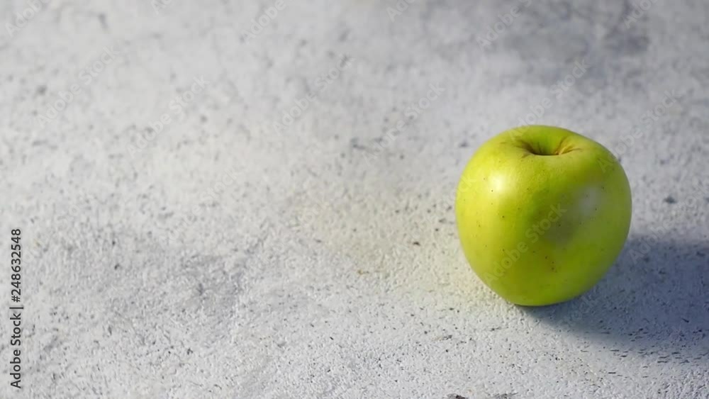 Organic Golden green apple rotating on gray cement background. Golden Apple on gray background rotation. Copy space for text. Food video HD. Organic Golden green apple rotating on gray cement background. Golden Apple on gray background rotation. Copy space for text. Food video HD.