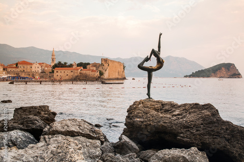 Dancing Girl Statue - an attractive sculpture and popular photo opportunity for tourists on background of old city Budva.. Most popular photo with Montenegro