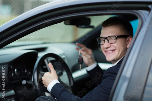smiling businessman showing the key of his new car © yurolaitsalbert
