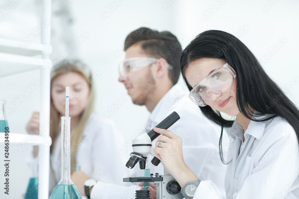 female scientist uses a microscope in the laboratory