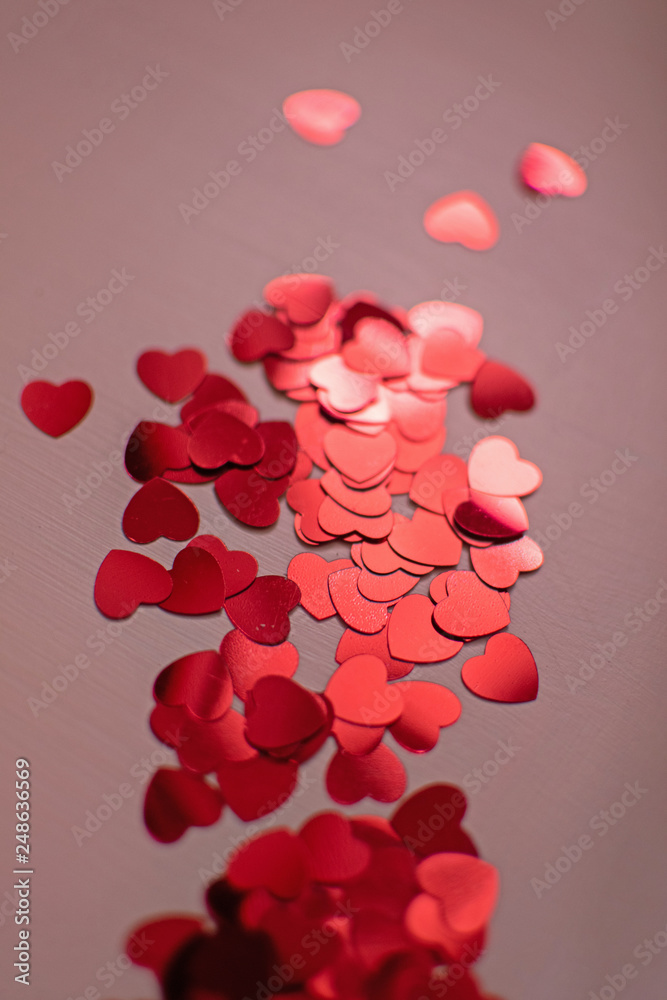 Red hearts. Heart confetti on coral background, glitter background. Color of the year 2019 - living coral. Red hearts. Heart confetti on coral background, glitter background. Color of the year 2019 - living coral.