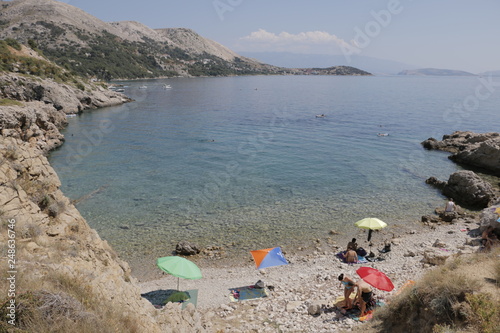 Mediterranean landscape during the summer. View of the beautiful, wild beach. Pleasant, quiet, calm bay, gulf. Hot, sunny day. Transparent, pure water in Adriatic Sea. Old Baska, Krk island, Croatia