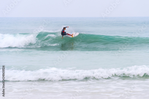 surfer riding wave motion blur