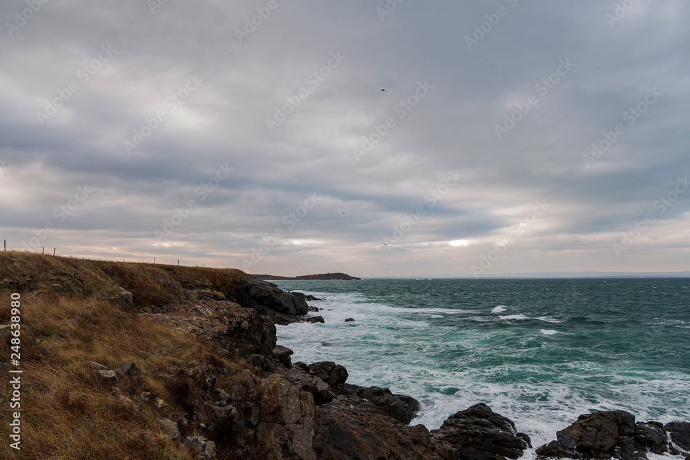 sea scenery in dramatic weather in the blue hour. a landscape with dramatic clouds and stormy water that breaks down on the shore and the rocks. sea scenery in dramatic weather in the blue hour. a landscape with dramatic clouds and stormy water that breaks down on the shore and the rocks.