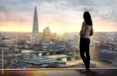 Young woman looking at the City of London at sunset. Planning the future, life and joy concept. © IRStone