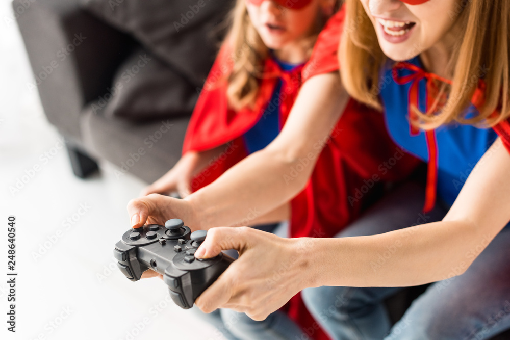 Partial view of woman and kid playing video game