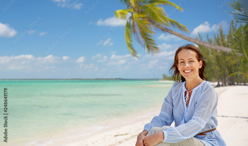 travel, tourism and summer vacation concept - happy smiling woman over tropical beach background in french polynesia