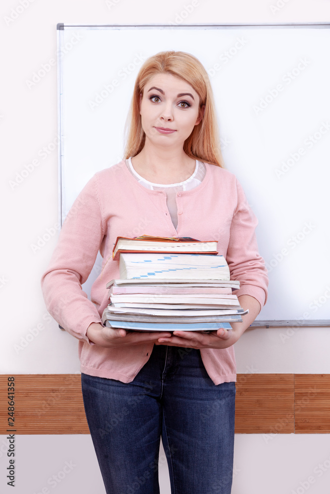 Portrait teacher woman femail classroom desk notebook young training school books lot puzzlement Portrait teacher woman femail classroom desk notebook young training school books lot puzzlement