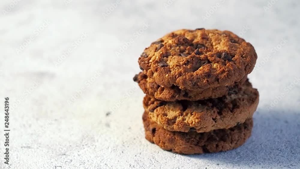 Stack of cookies rotate on gray cement background. Cookie with chocolate, copy space for text. Seamless looped HD video