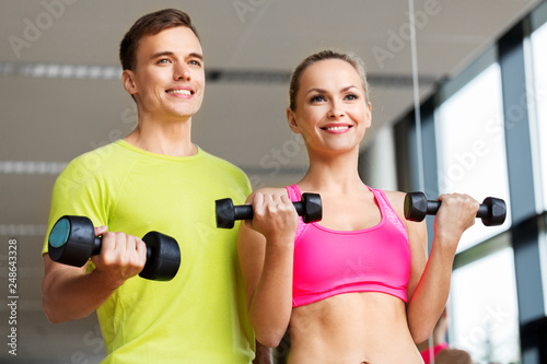 sport, fitness and people concept - couple with dumbbells exercising in gym © Syda Productions