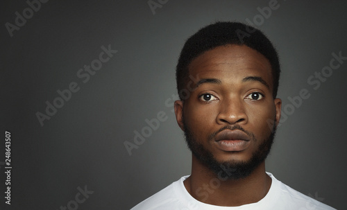 Serious african-american man on black studio background