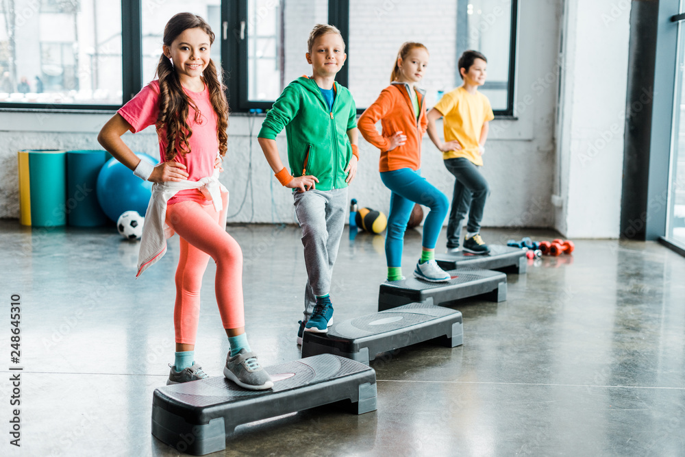 Fototapeta premium Group of kids using step platforms in gym