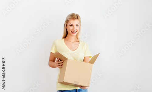 people and moving to new place concept - happy woman holding cardboard box