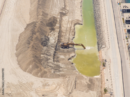 Excavator machinery at construction site, desert in background. Accelerated video view.