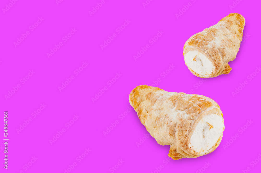 Pair of baked rolls with cream on violet background with copy space for your text