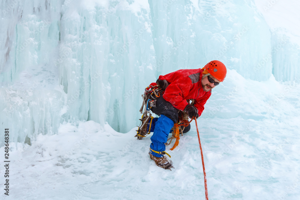 ice climber arranges rope protection on the glacier