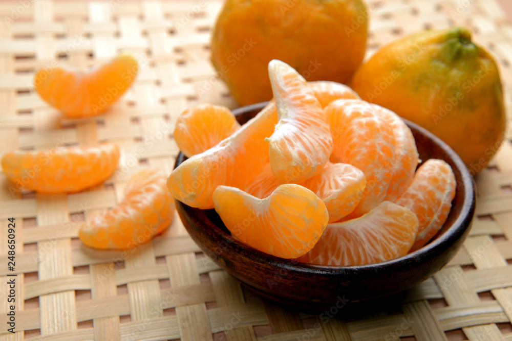 tangerines or orange fruit slices in a bowl on wooden table tangerines or orange fruit slices in a bowl on wooden table