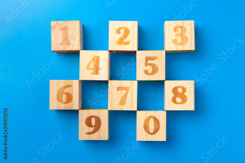 Numbers. Wooden colorful alphabet blocks on blue background, flat lay, top view.