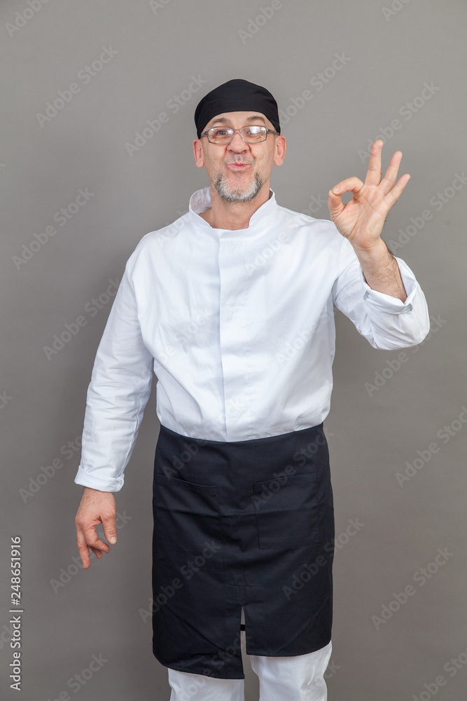 Elderly chef on grey background, isolated, concept Elderly chef on grey background, isolated, concept