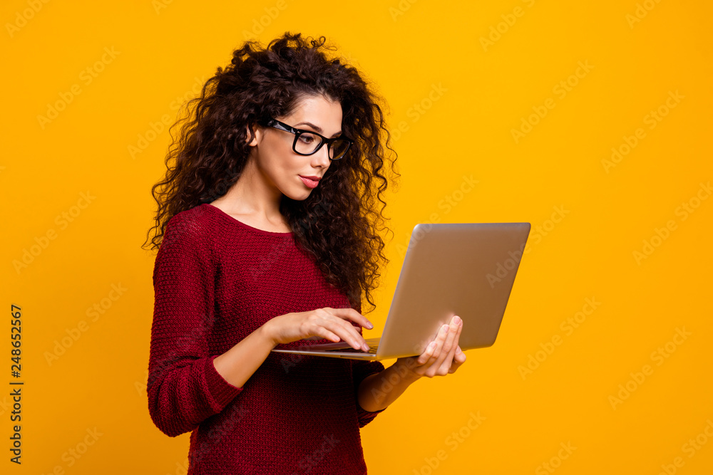 Profile side view portrait of her she nice clever smart intelligent genius cute attractive pretty cheerful wavy-haired lady holding in hands laptop isolated over bright vivid shine orange background Profile side view portrait of her she nice clever smart intelligent genius cute attractive pretty cheerful wavy-haired lady holding in hands laptop isolated over bright vivid shine orange background