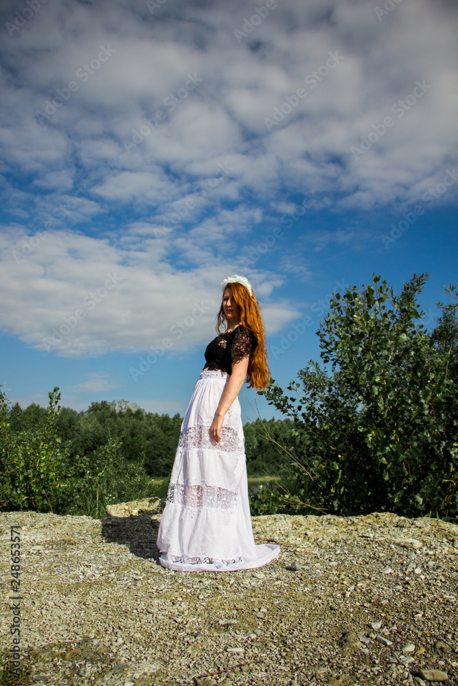 Young beautiful redhead woman on the stone