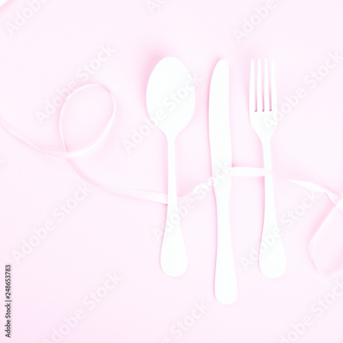Festive table setting with fork  knife and hearts  on pink pastel background.Romantic dinner. Space for text. Top view.