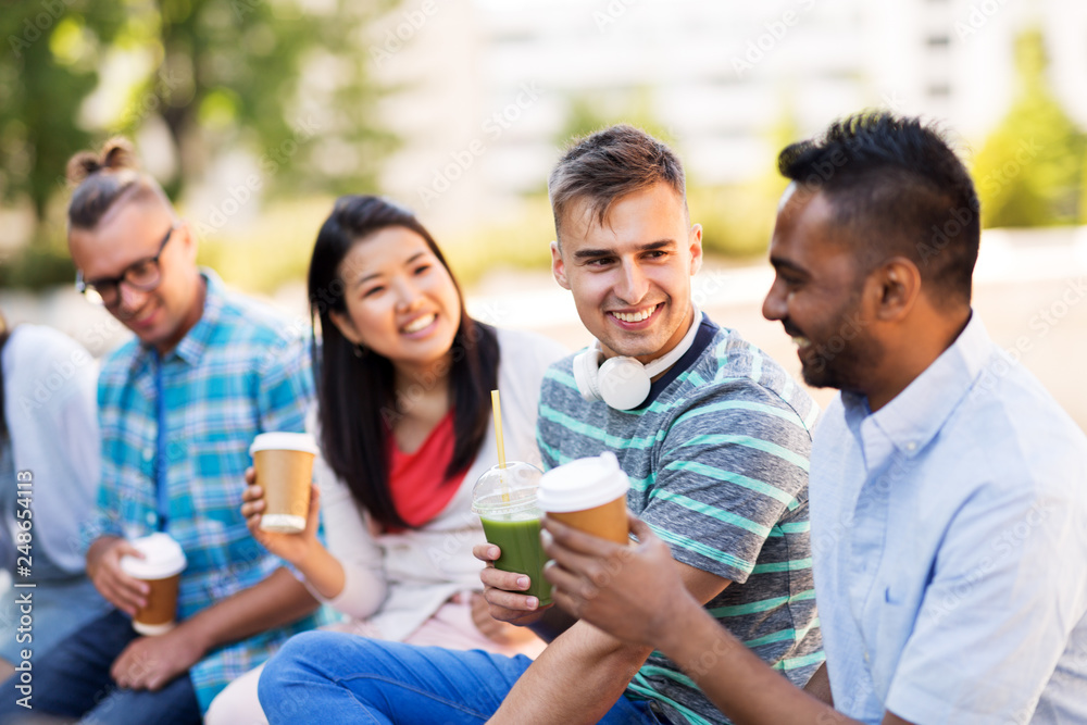 people, friendship and international concept - group of happy friends drinking coffee and juice talking in city people, friendship and international concept - group of happy friends drinking coffee and juice talking in city