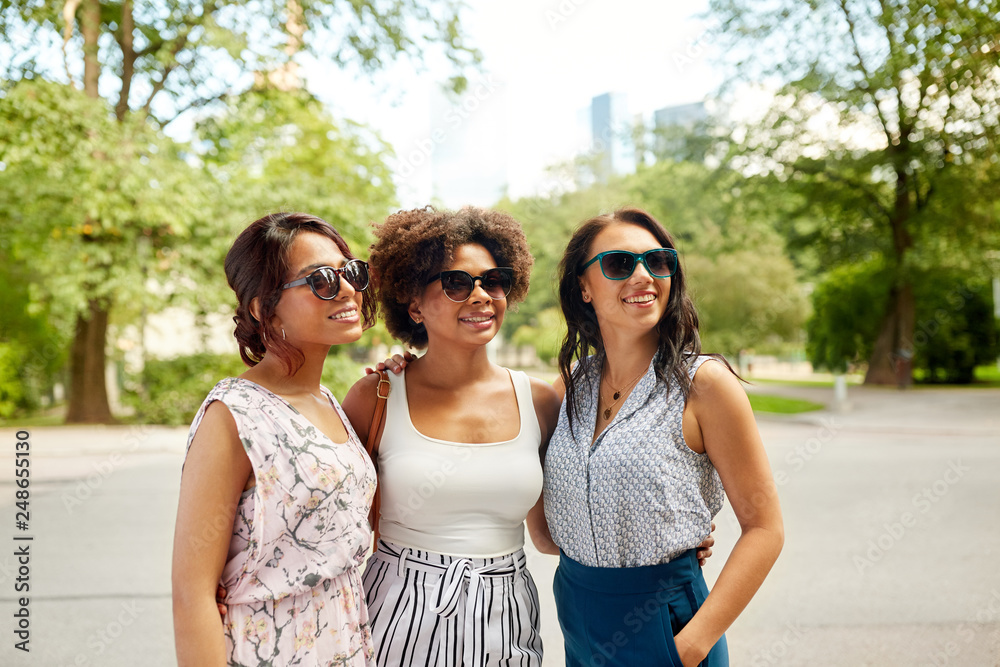 female friendship, people and leisure - happy young women in sunglasses at summer park