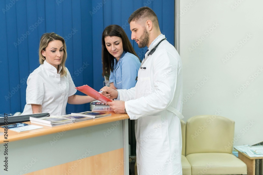 Fototapeta premium Male doctor and two female nurses inside a hospital, concept