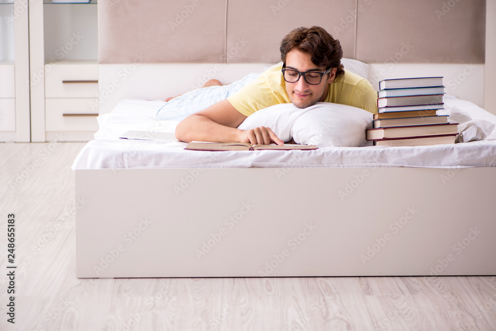 Young student studying in bed for exams Young student studying in bed for exams