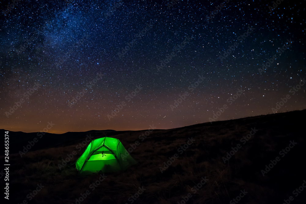 green iluminated tent under starry sky