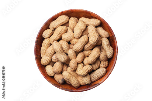 Peanuts in shells inside round wooden bowl isolated on white. Helathy vegetarian diet food background with empty copy space.