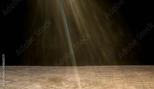 Old empty wood on a black background and a beam of light through.