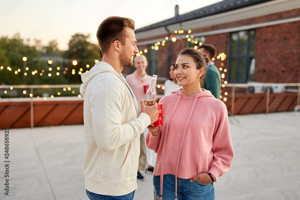 leisure, celebration and people concept - happy friends with non alcoholic drinks at rooftop party in evening