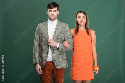 beautiful couple in vintage clothes posing isolated on green