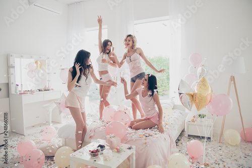 Nice-looking cool crazy careless carefree attractive feminine fit thin slim graceful cheerful funny girlfriends having fun showing v-sign in light white interior decorated house photo