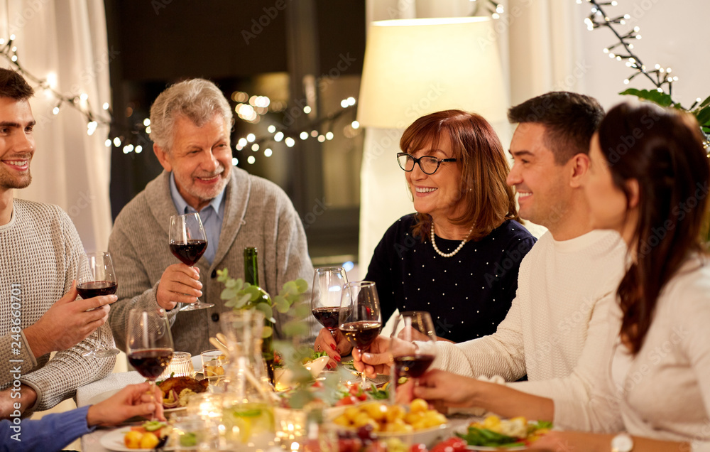 celebration, holidays and people concept - happy family having dinner party, drinking red wine and toasting at home