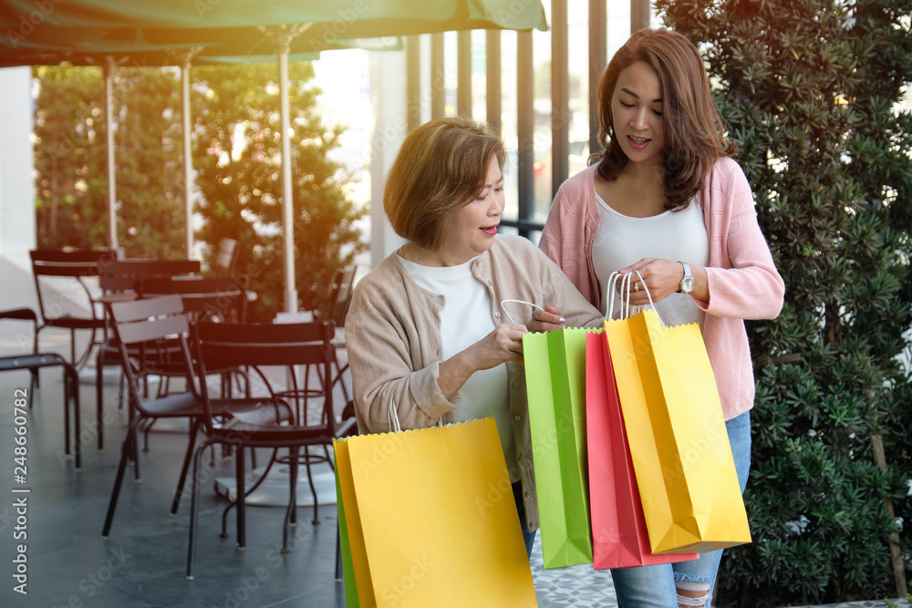 Mother with her daughter holding shopping bags in department store, happy family and people concept. Mother with her daughter holding shopping bags in department store, happy family and people concept.