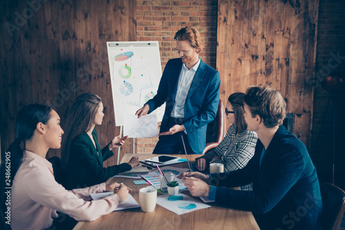 Close up photo business people he him his she her partners charts office together tell talk conversation about income earnings money discuss future plans dressed suits formal wear photo