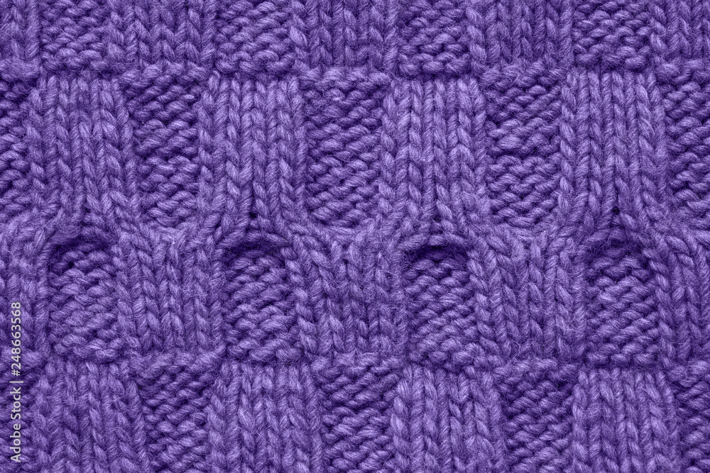 Violet knitted texture with a relief pattern. Handmade Knitwear. Background. Color of the year 2019 concept.
