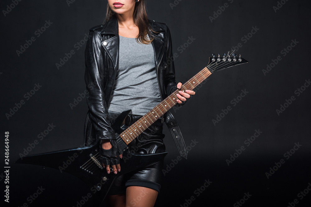 cropped view of woman in leather jacket with electric guitar isolated on black