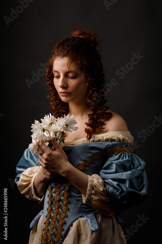 Baroque woman with closed eyes holding flowers