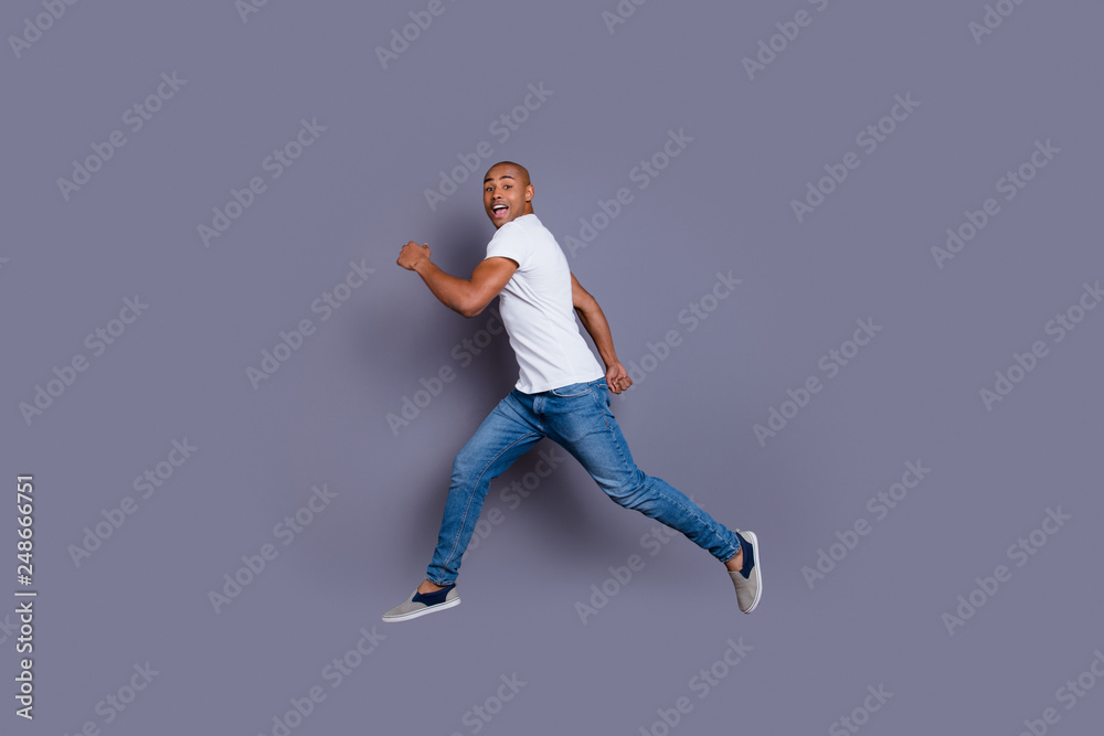 Full length body size profile side view portrait of his he nice handsome attractive masculine cheerful guy in white shirt jeans having fun running away isolated over gray pastel background