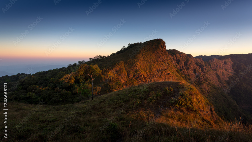 Mountain landscape with the sunrise and orange horizon of sunlight at morning, Thailand. 