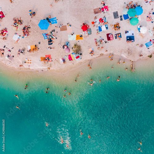 aerial view of sunny sandy beach with blue azure water. summer vacation