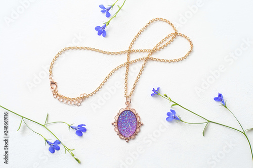 Beautiful female pendant on a chain, decoration for girls on white background, purple stone in gold frame