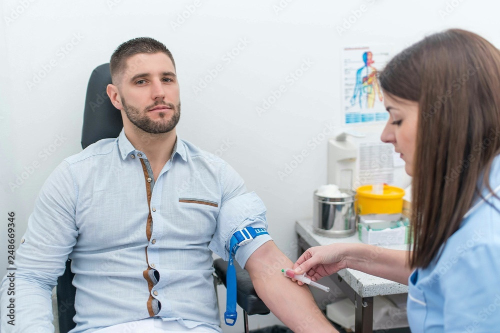 Female doctor sits down with her patient to take a blood sample